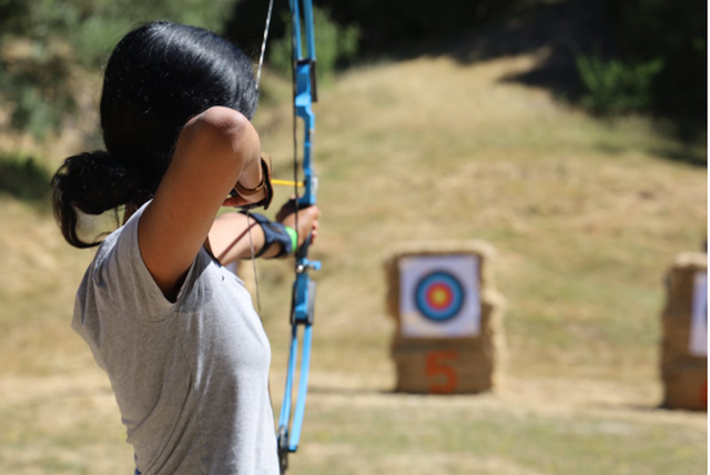 Picture of a Scout at the archery range about to loose an arrow.