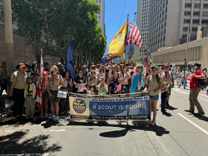 group picture at pride parade holding banner that says "a scout is equal"
