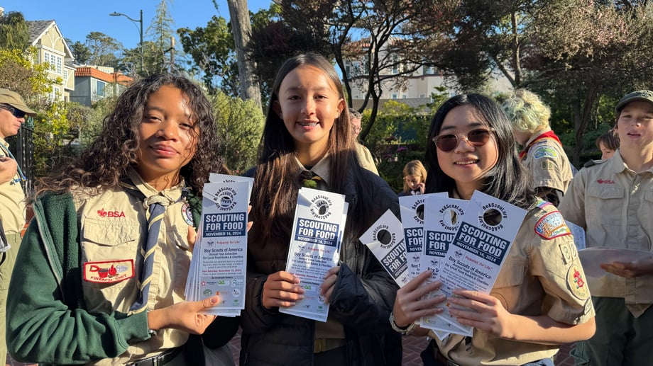 three scouts holding scouting for food door hangers