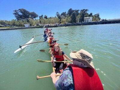 scouts and adults in a outrigger canoe